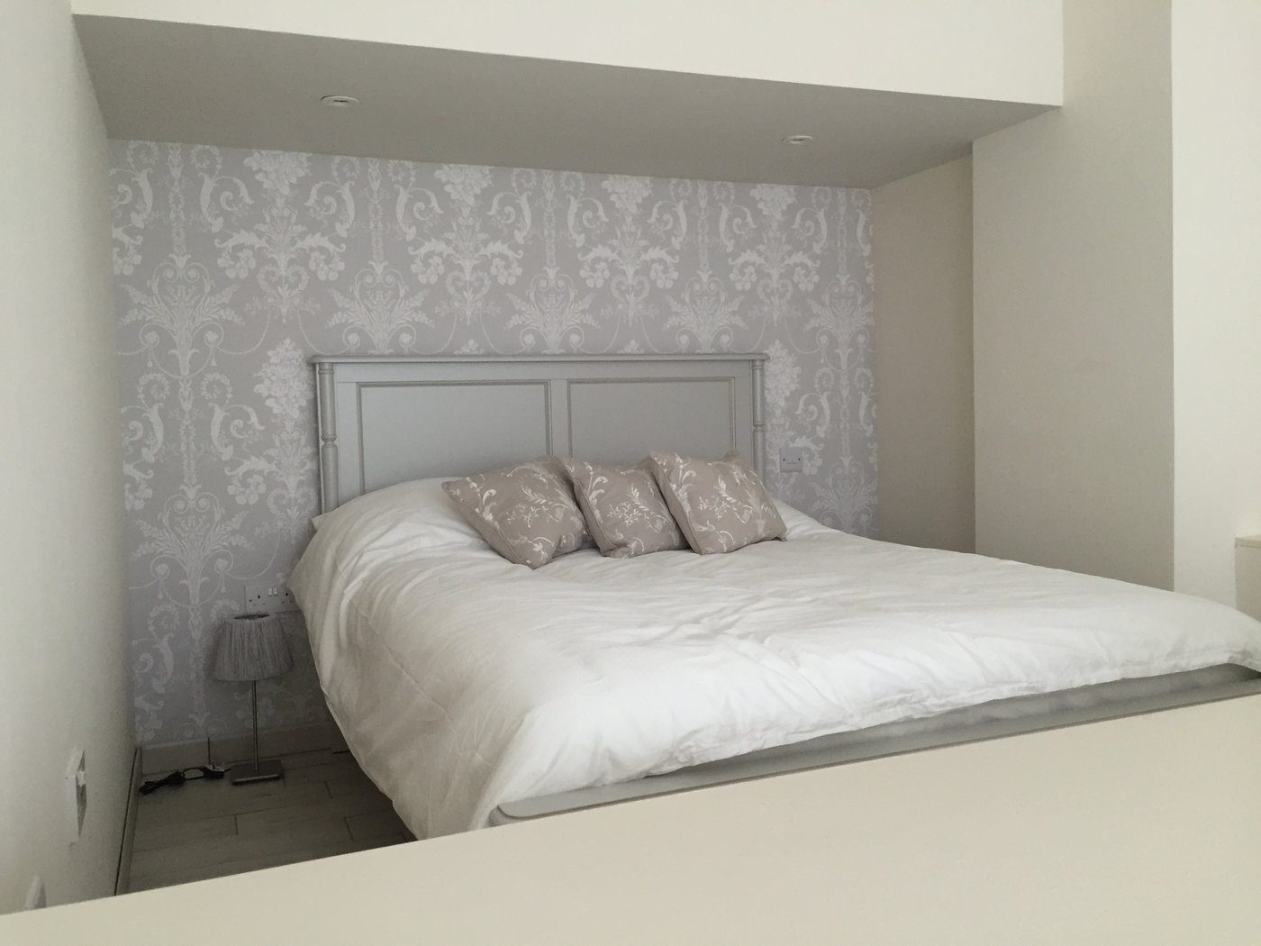 Feature wallpaper behind a bed, hung by LAP Decoration