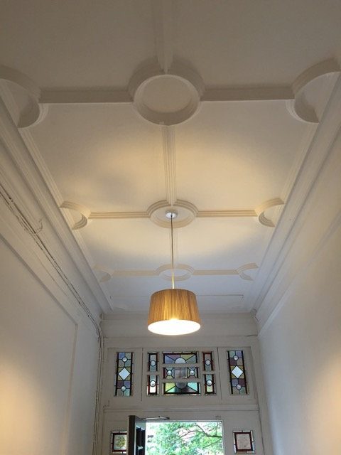 Decorated ceiling and fanlight in a communal hallway